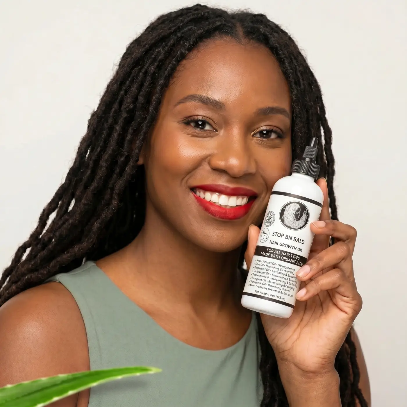 Retail partner holding STOP BN BALD Hair Oil