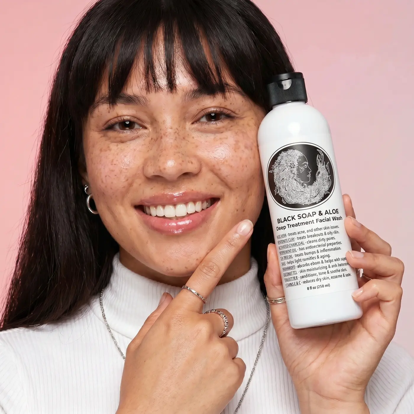 Customer holding Face and Body Liquid Black Soap with Aloe